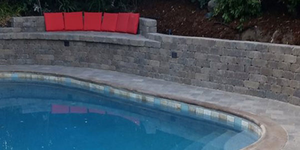 Stone paver retaining wall near swimming pool